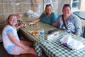Family eating fair food sitting on bench at Darke County Fair